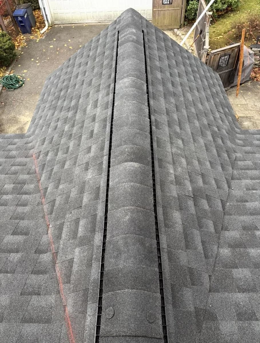 Hip and ridge cap detail on Montclair roof with autumn trees in background
