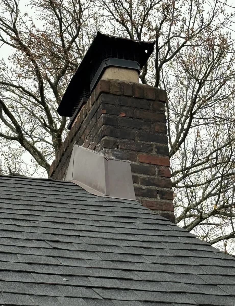 Rebuilt brick chimney with new gray flashing on Charcoal shingled roof — Montclair
