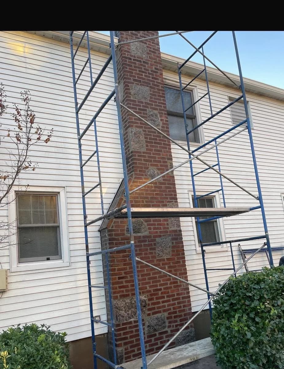 Repointed 30-foot brick chimney mid-project with scaffold setup — Nutley