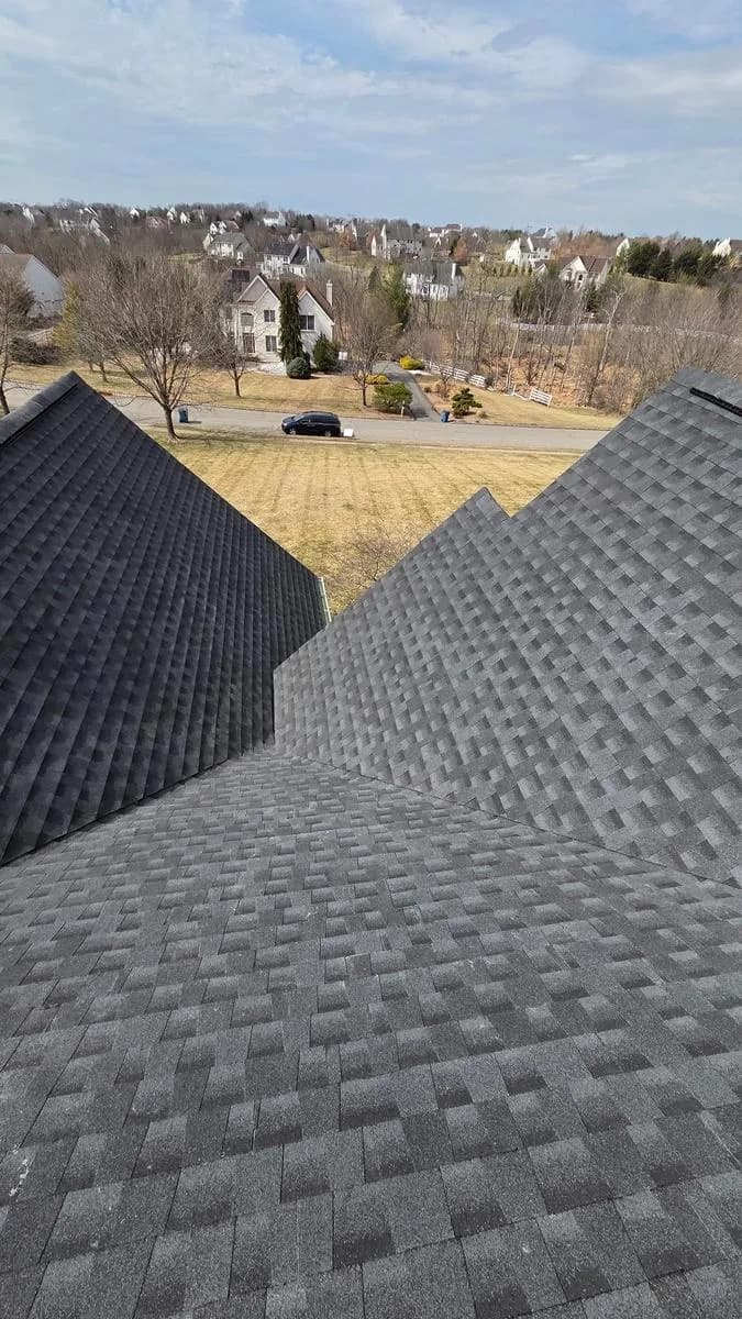 Long ridge run with new shingles and Apex service van in driveway — Raritan Township