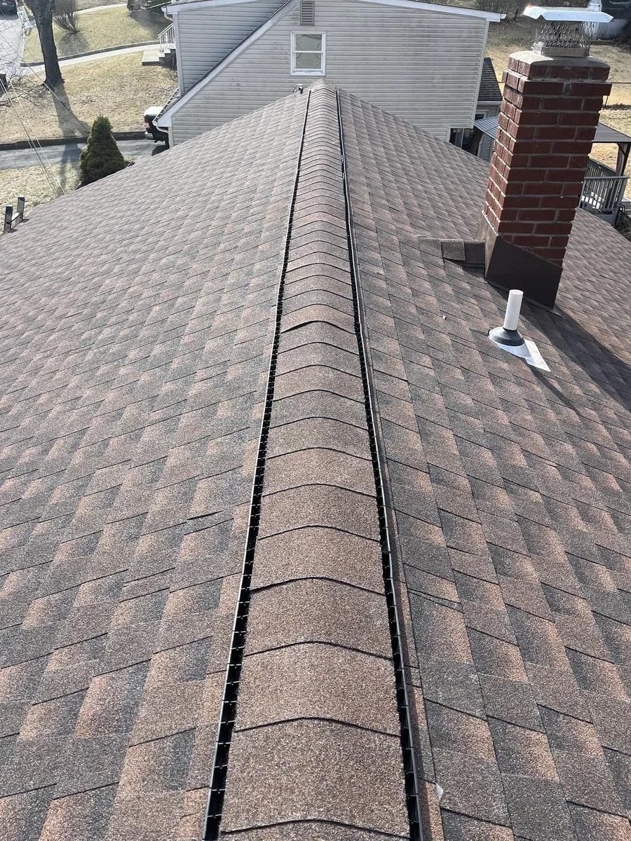 Long ridge view of new GAF Timberline HDZ Hickory roof with brick chimney in background — Rockaway, NJ