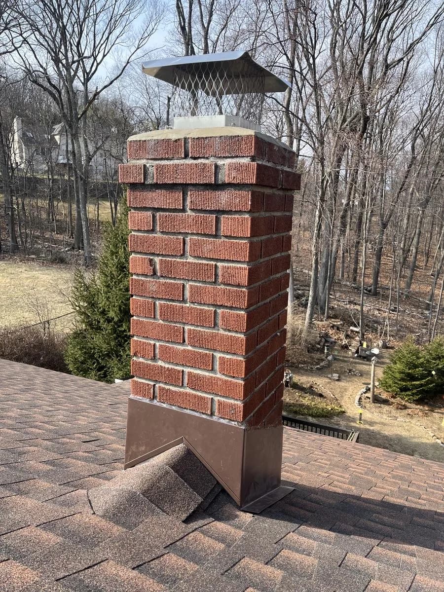 Brick chimney with rechiseled crown cement and new flashing on Hickory shingles — Rockaway, NJ