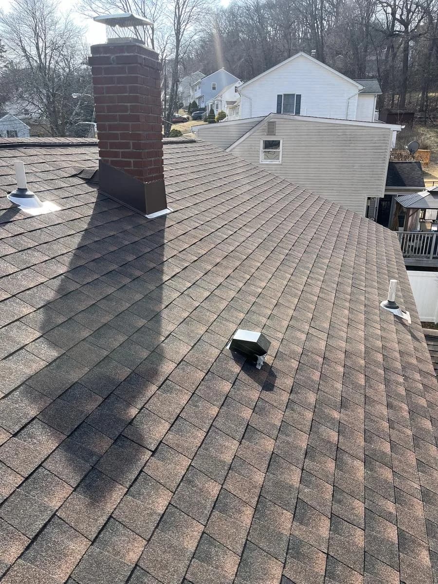 Roof slope view with chimney, pipe collars, and new shingles — Rockaway, NJ