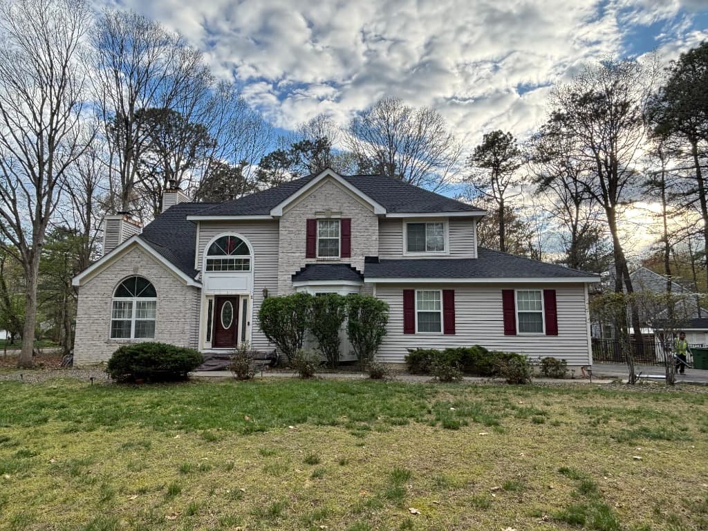 Professional roofing crew installing an asphalt shingle roof on a New Jersey suburban home
